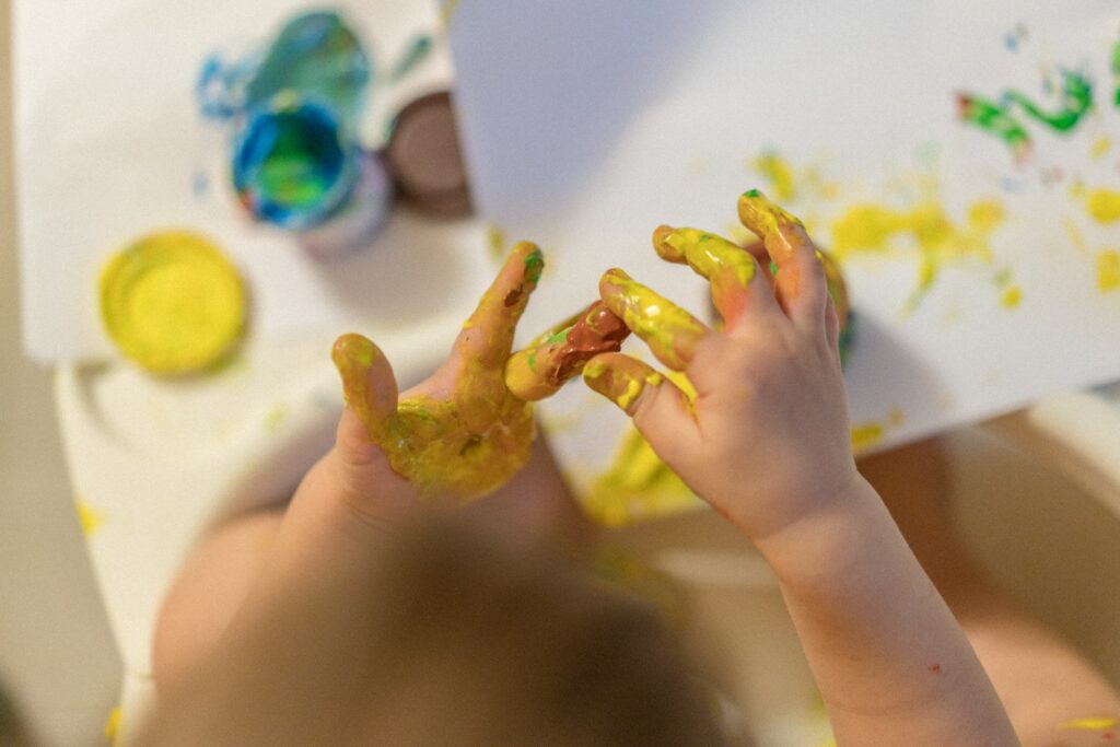 3 year old kid painting with his fingers